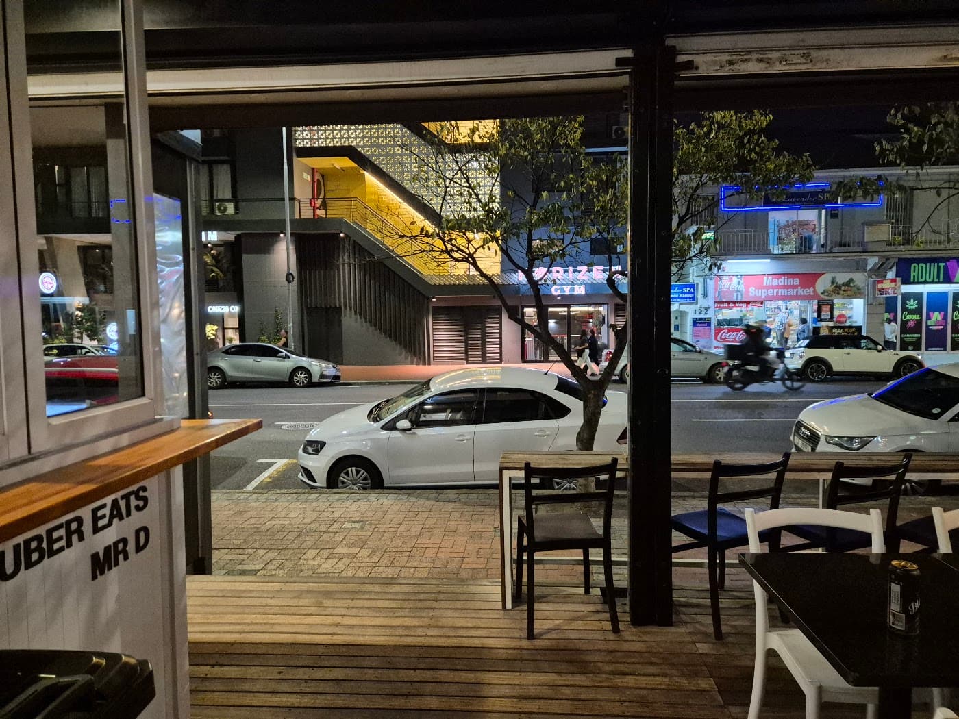 An outdoor rooftop cafe deck with an Uber Eats delivery sign