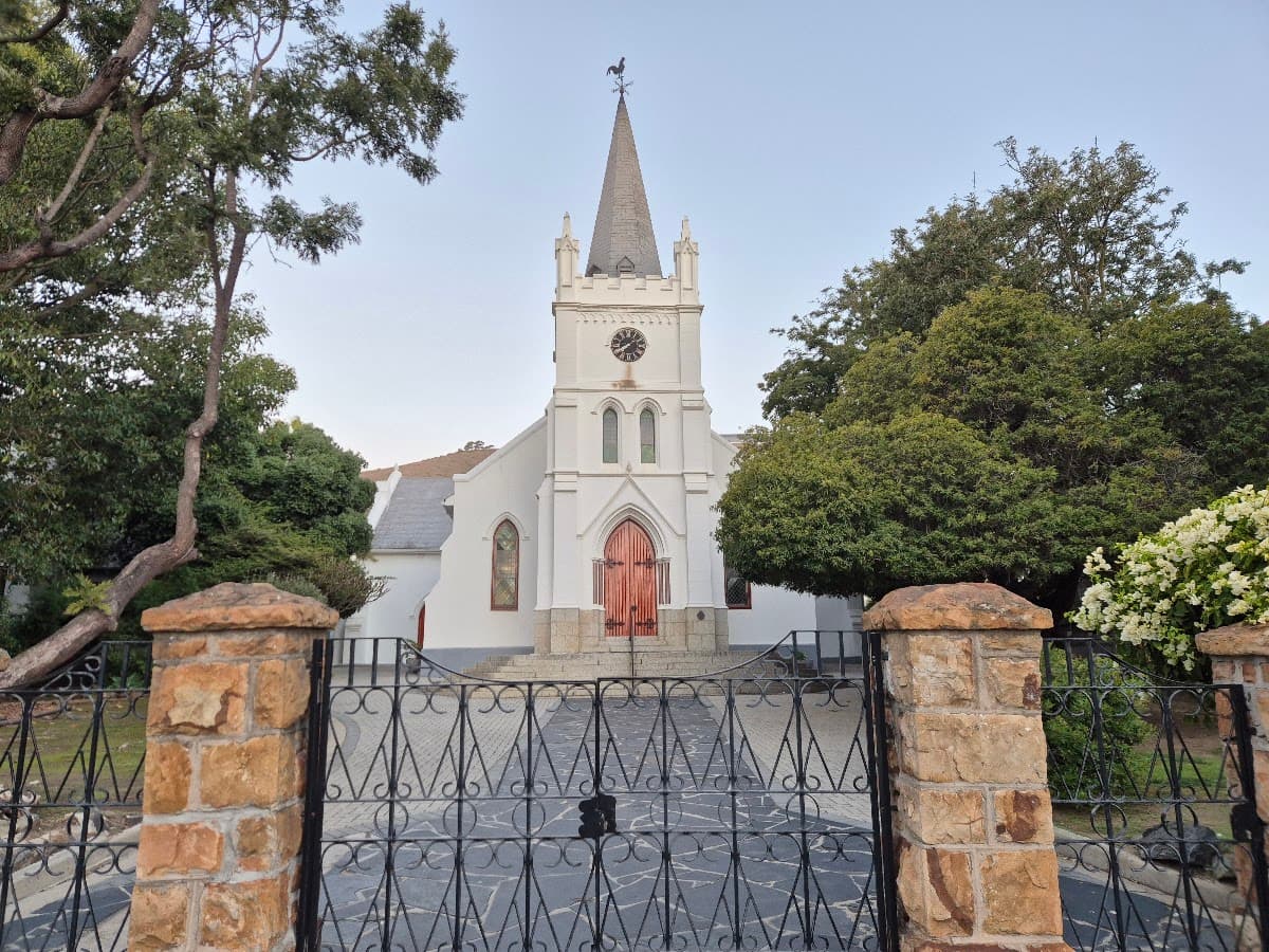 A white church behind a wrought-iron gate